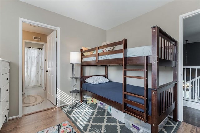 bedroom featuring visible vents, baseboards, and wood finished floors