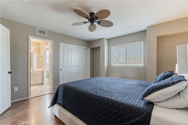 bedroom with connected bathroom, ceiling fan, baseboards, wood finished floors, and visible vents