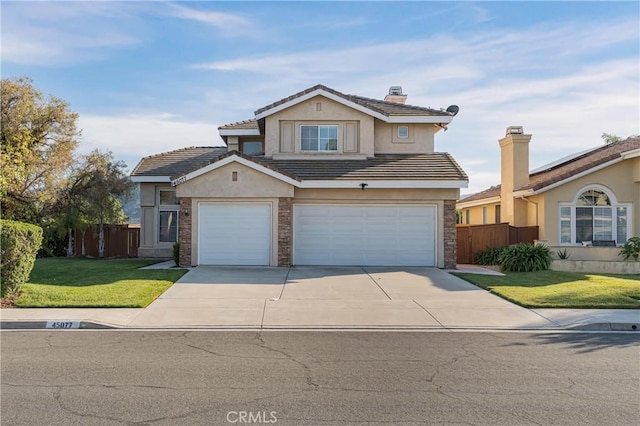 traditional-style home with fence, a front lawn, driveway, and stucco siding