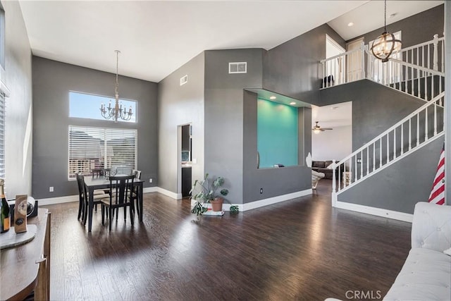 dining room with baseboards, a high ceiling, wood finished floors, and visible vents