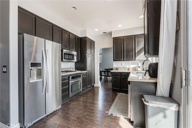 kitchen featuring dark wood-type flooring, a sink, dark brown cabinets, and stainless steel appliances