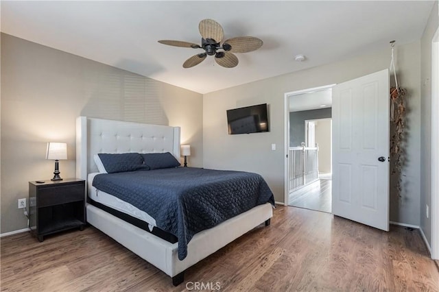bedroom with baseboards, ceiling fan, and wood finished floors