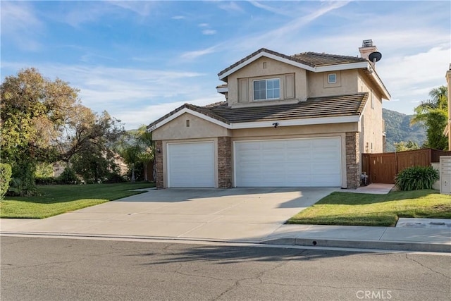 traditional home featuring fence, stucco siding, concrete driveway, and stone siding