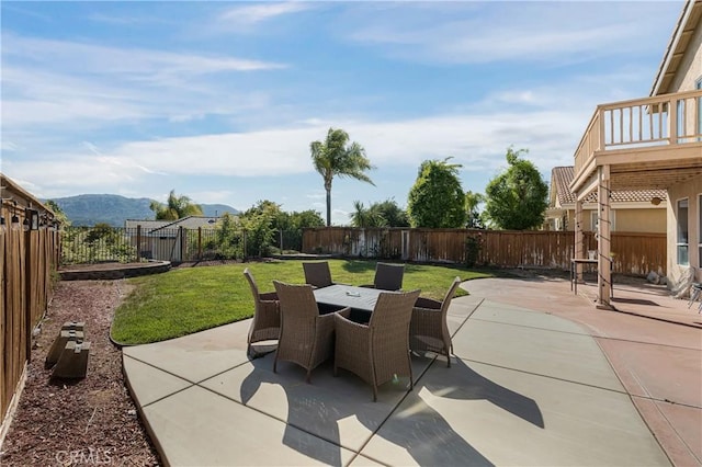 view of patio / terrace with a fenced backyard, outdoor dining space, and a mountain view