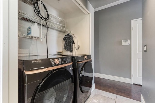 laundry area with separate washer and dryer, baseboards, and wood finished floors