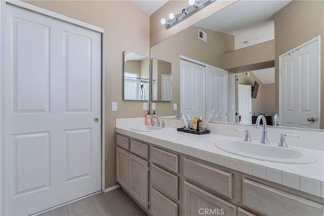 bathroom with double vanity, visible vents, and a sink