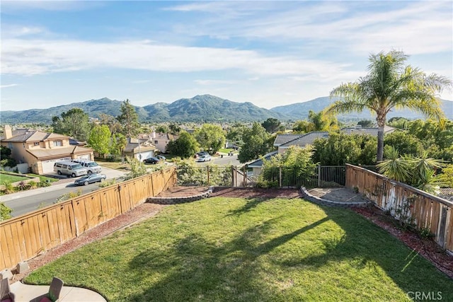view of yard with a fenced backyard, a mountain view, and a residential view