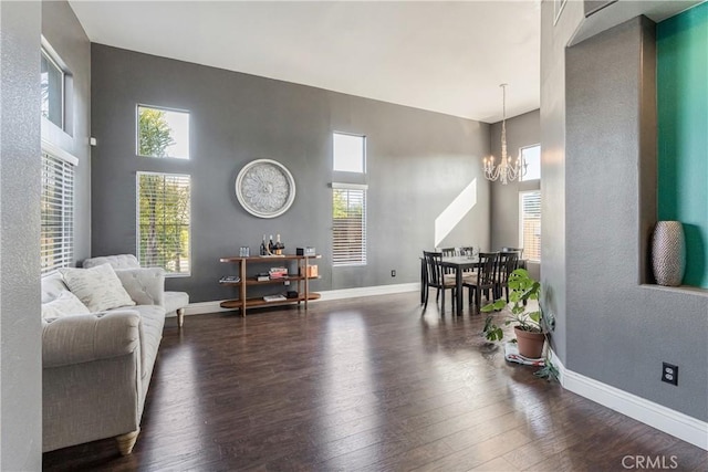 living room with plenty of natural light, dark wood finished floors, and a notable chandelier