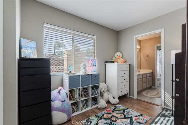 bedroom with light wood-style flooring and ensuite bathroom