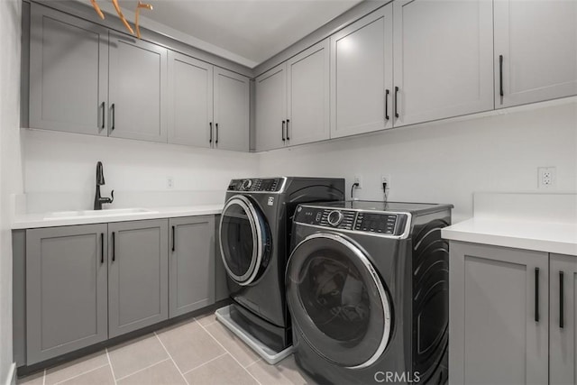 297 Sawbuck, Irvine, CA 92618 - laundry area featuring washer and clothes dryer, cabinet space, and light tile patterned flooring