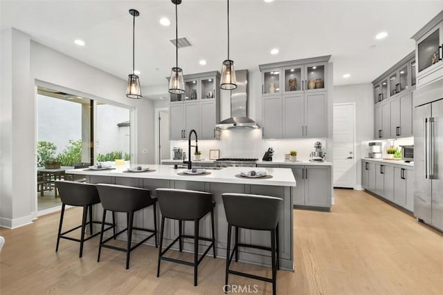 297 Sawbuck, Irvine, CA 92618 - kitchen with wall chimney range hood, a sink, a center island with sink, backsplash, and recessed lighting