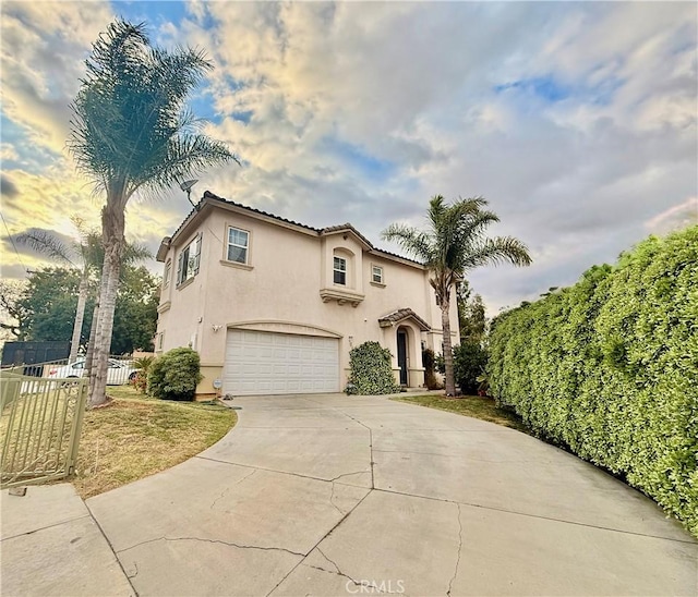 7163 Watcher St, Commerce, CA 90040 - mediterranean / spanish-style house with stucco siding, a garage, fence, and concrete driveway