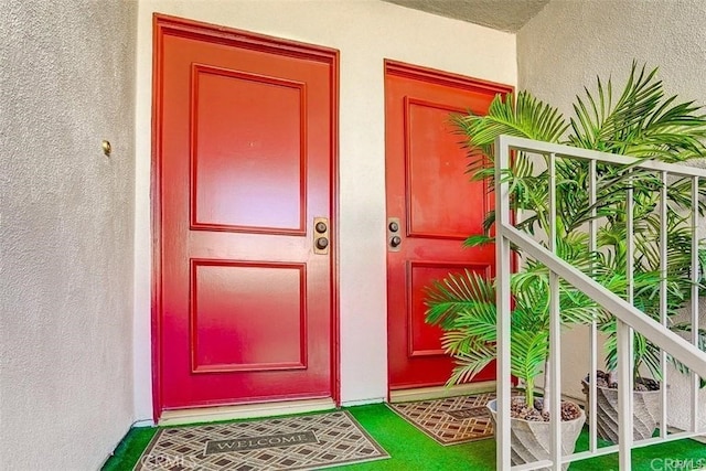 doorway to property featuring stucco siding