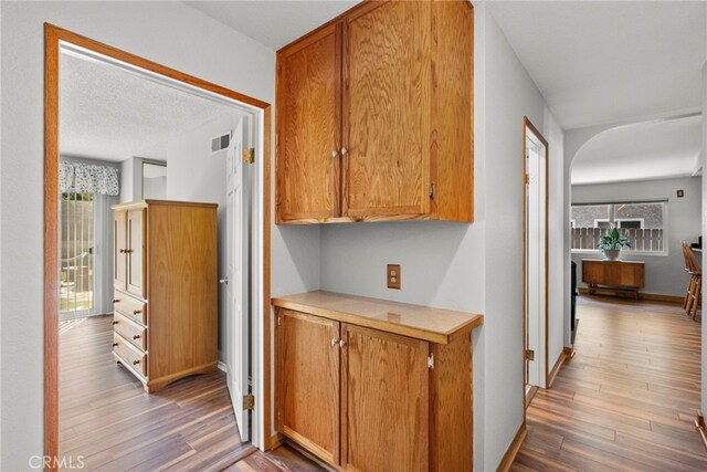 27736 Cherry Creek Dr, Valencia, CA 91354 - hall featuring arched walkways, baseboards, visible vents, and wood finished floors