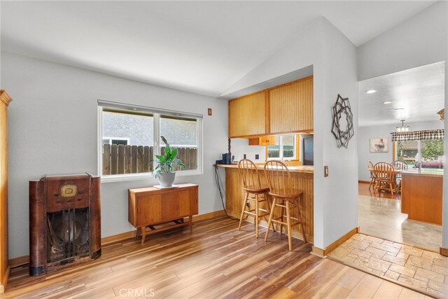 27736 Cherry Creek Dr, Valencia, CA 91354 - kitchen featuring a breakfast bar area, vaulted ceiling, and wood finished floors