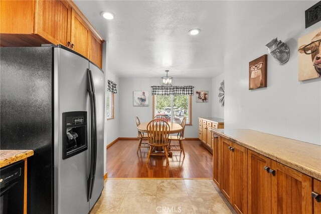 27736 Cherry Creek Dr, Valencia, CA 91354 - kitchen with light countertops, brown cabinetry, stainless steel fridge, and black dishwasher