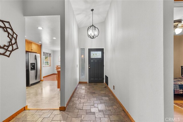 27736 Cherry Creek Dr, Valencia, CA 91354 - entryway with stone tile flooring, baseboards, and a notable chandelier