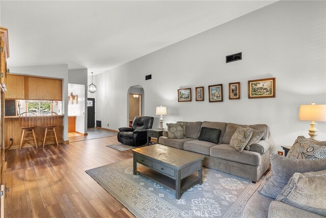 27736 Cherry Creek Dr, Valencia, CA 91354 - living room featuring visible vents, arched walkways, wood-type flooring, and high vaulted ceiling