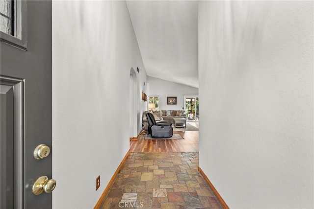 27736 Cherry Creek Dr, Valencia, CA 91354 - corridor featuring baseboards, arched walkways, stone tile flooring, and lofted ceiling
