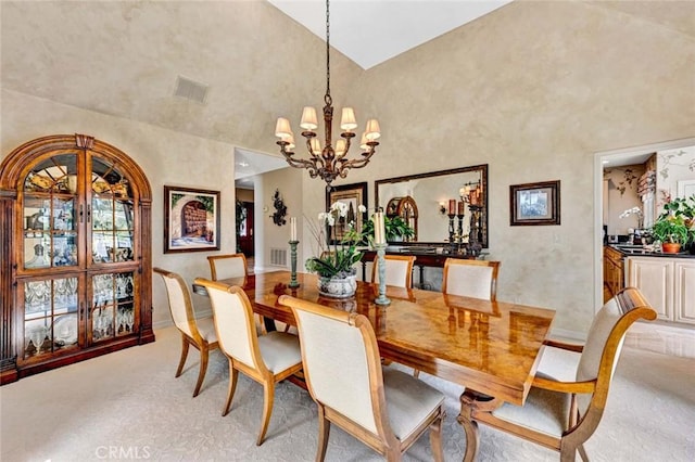 10302 Broadview Pl, North Tustin, CA 92705 - dining area featuring light colored carpet, visible vents, high vaulted ceiling, and an inviting chandelier