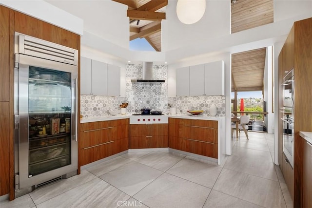 14 Woodsong Dr, Laguna Niguel, CA 92677 - kitchen with wall chimney range hood, tasteful backsplash, light countertops, and white stovetop