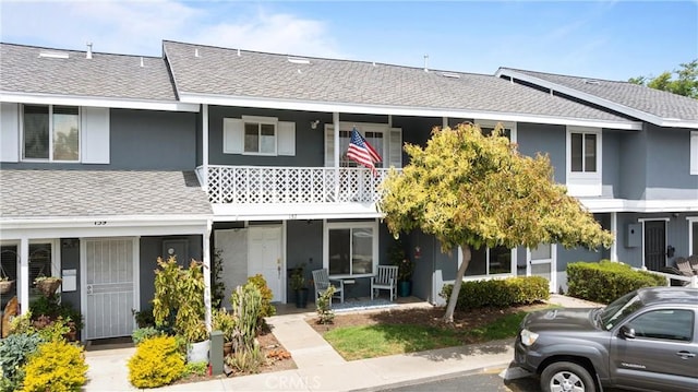 157 Yorktown Ln, Costa Mesa, CA 92626 - townhome / multi-family property featuring roof with shingles, stucco siding, and a porch
