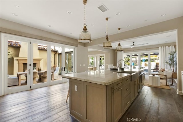 101 Via Artemesia, San Clemente, CA 92672 - kitchen featuring dark wood-style floors, french doors, an island with sink, recessed lighting, and light stone counters