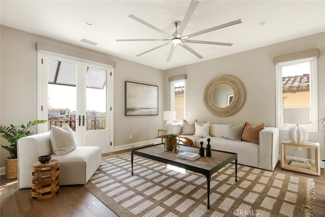 living room with french doors, ceiling fan, plenty of natural light, and wood finished floors