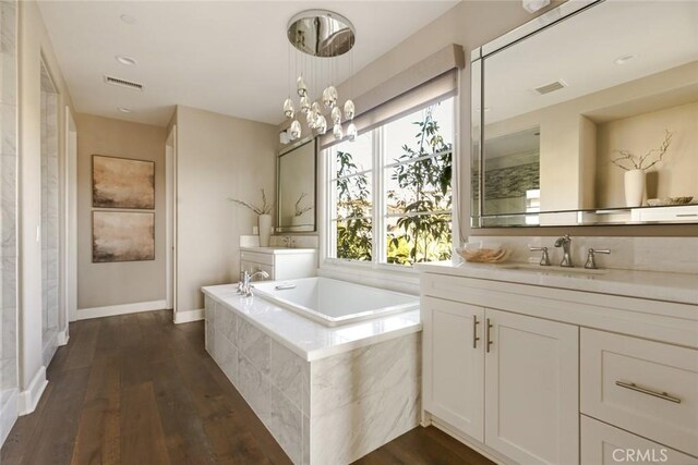 101 Via Artemesia, San Clemente, CA 92672 - bathroom with two vanities, a bath, wood finished floors, and a chandelier