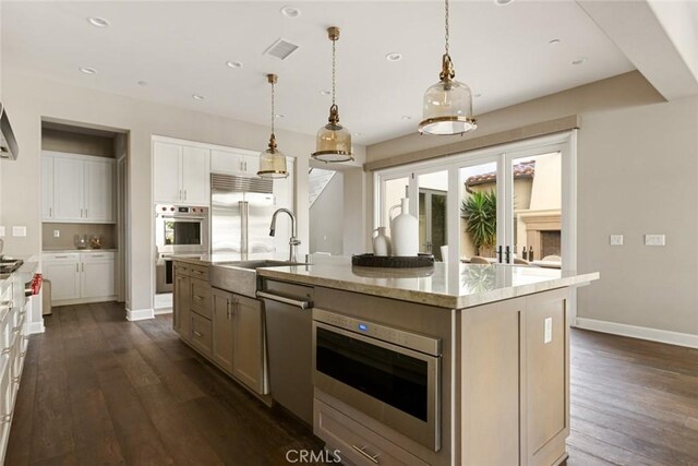 101 Via Artemesia, San Clemente, CA 92672 - kitchen with appliances with stainless steel finishes, dark wood-style flooring, an island with sink, recessed lighting, and light stone countertops