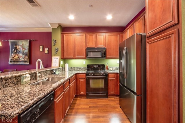 28365 Socorro St Unit 45, Murrieta, CA 92563 - kitchen with black appliances, a sink, wood finished floors, stone counters, and a peninsula