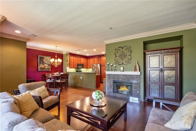28365 Socorro St Unit 45, Murrieta, CA 92563 - living room featuring a chandelier, ornamental molding, wood finished floors, recessed lighting, and a premium fireplace