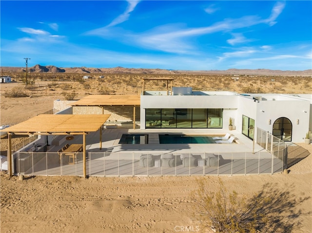 63973 Gold Nugget Rd, Joshua Tree, CA 92252 - back of house featuring stucco siding, an outdoor pool, a mountain view, and a desert view