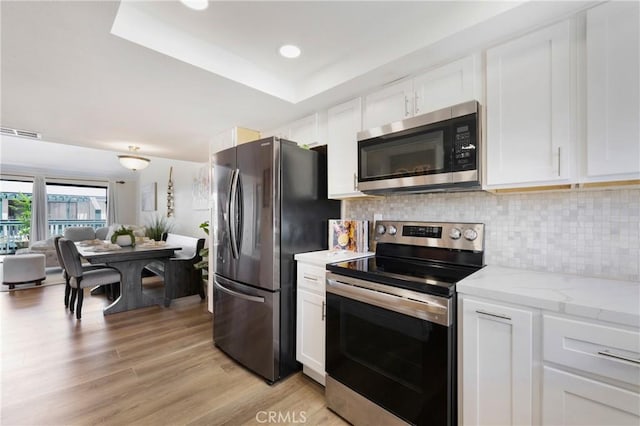 12812 Timber Rd Unit 22, Garden Grove, CA 92840 - kitchen with stainless steel appliances, tasteful backsplash, and white cabinets