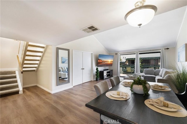 12812 Timber Rd Unit 22, Garden Grove, CA 92840 - dining space with stairs, vaulted ceiling, healthy amount of natural light, and wood finished floors