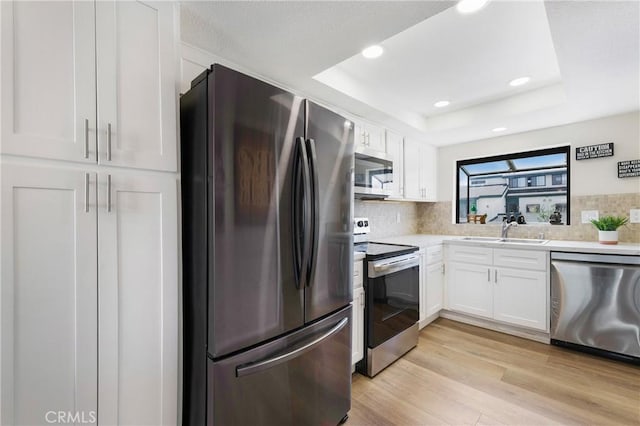 12812 Timber Rd Unit 22, Garden Grove, CA 92840 - kitchen featuring stainless steel appliances, a tray ceiling, white cabinets, tasteful backsplash, and recessed lighting