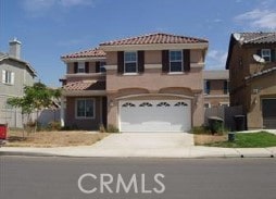 view of front of home featuring a tiled roof, an attached garage, and driveway