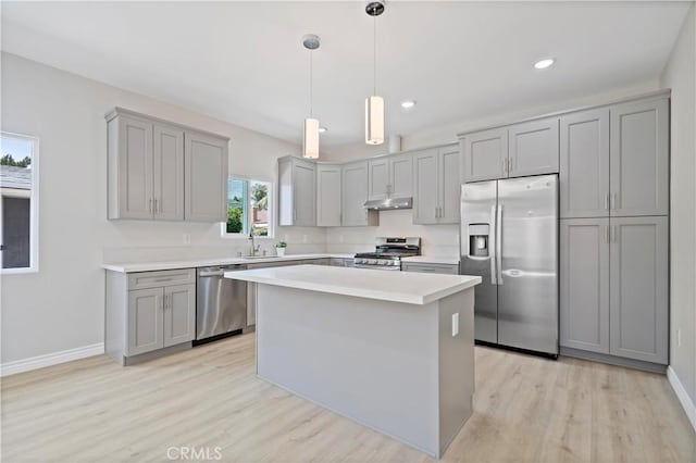 kitchen featuring light wood-style floors, gray cabinets, appliances with stainless steel finishes, and under cabinet range hood
