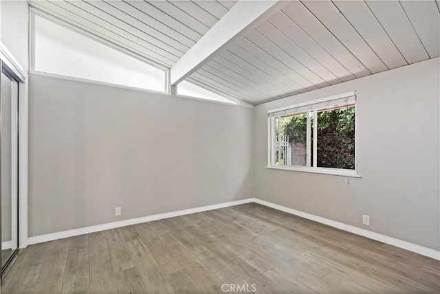 empty room featuring vaulted ceiling with beams, baseboards, wood ceiling, and hardwood / wood-style floors