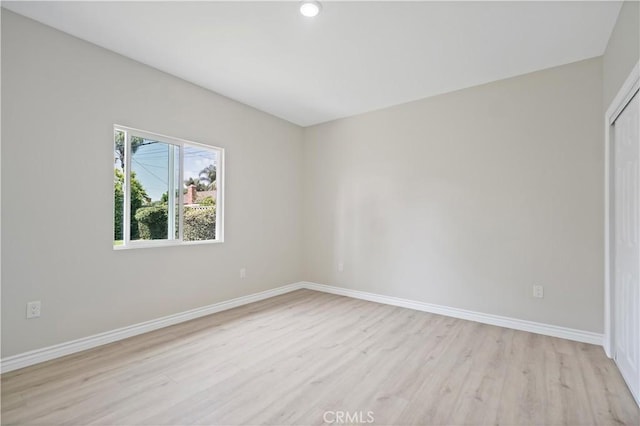 unfurnished room featuring baseboards, recessed lighting, and light wood finished floors