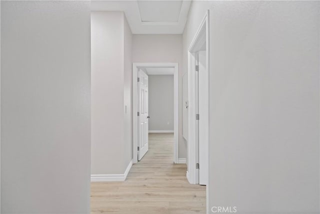 hallway with baseboards and light wood-style flooring