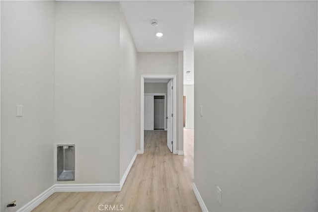 corridor featuring light wood-style floors and baseboards