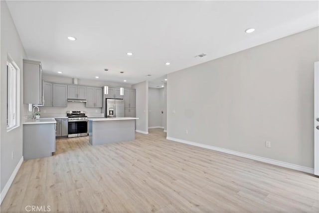 kitchen with light countertops, gray cabinetry, baseboards, and appliances with stainless steel finishes