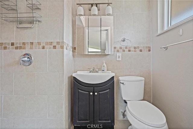bathroom with vanity, toilet, and tiled shower