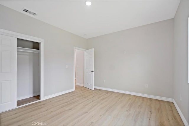 unfurnished bedroom featuring light wood-style floors, recessed lighting, baseboards, visible vents, and a closet