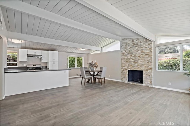 living room with a fireplace, baseboards, lofted ceiling with beams, and wood finished floors