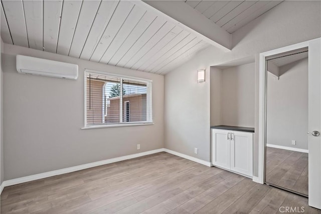 spare room with light wood finished floors, an AC wall unit, baseboards, vaulted ceiling with beams, and wood ceiling