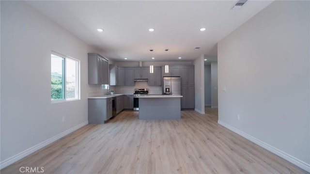kitchen with visible vents, light countertops, a sink, appliances with stainless steel finishes, and gray cabinetry