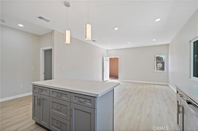 kitchen featuring gray cabinets, visible vents, pendant lighting, light countertops, and light wood-style floors