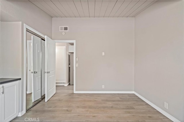 unfurnished bedroom with light wood-style floors, baseboards, wood ceiling, and visible vents